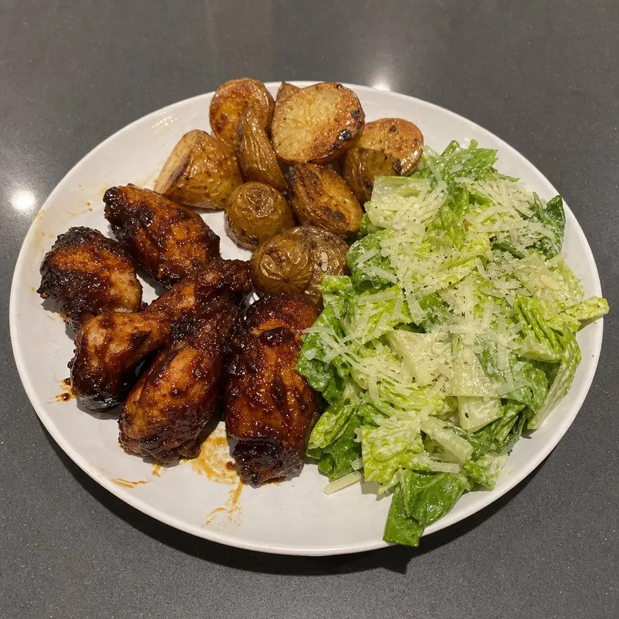 Ailes de poulet BBQ au four, salade César aux cœurs de romaine et pommes de terre rôties