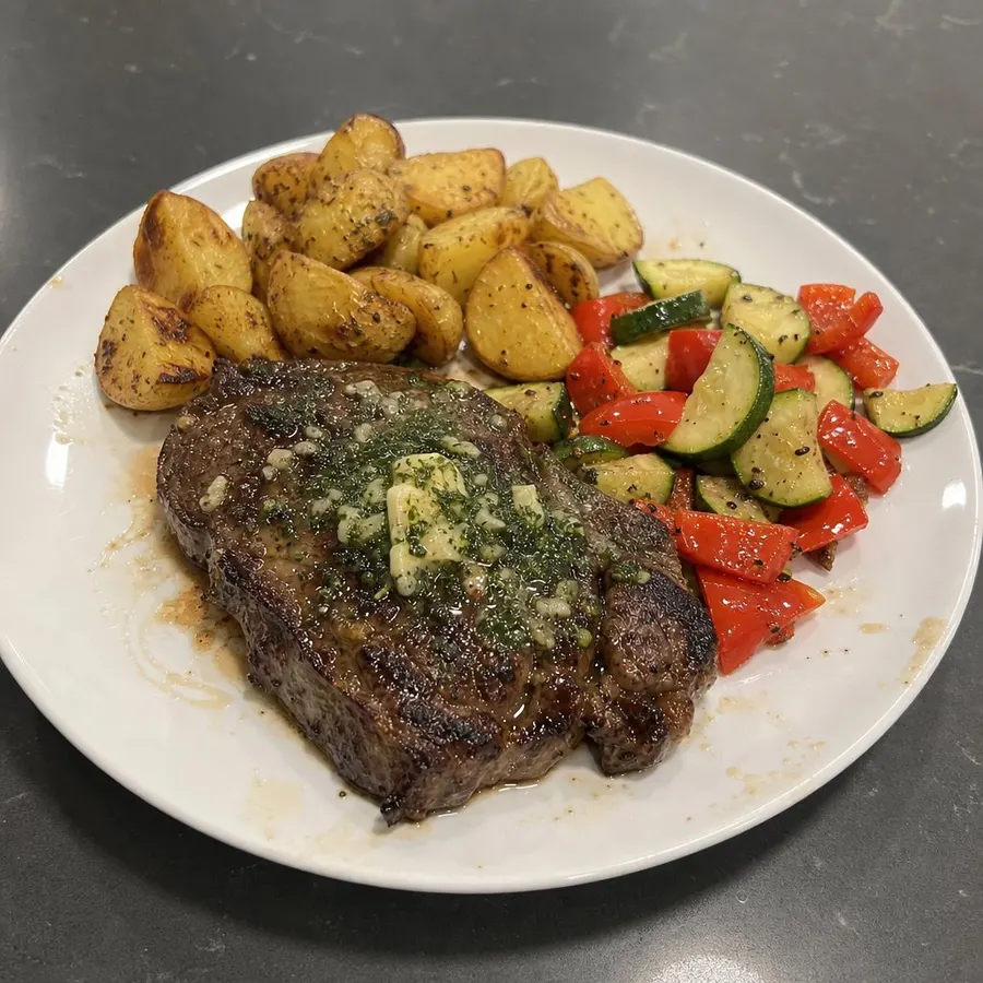 Bifteck d'aloyau grillé, beurre à l'ail, pommes de terre rôties et courgettes