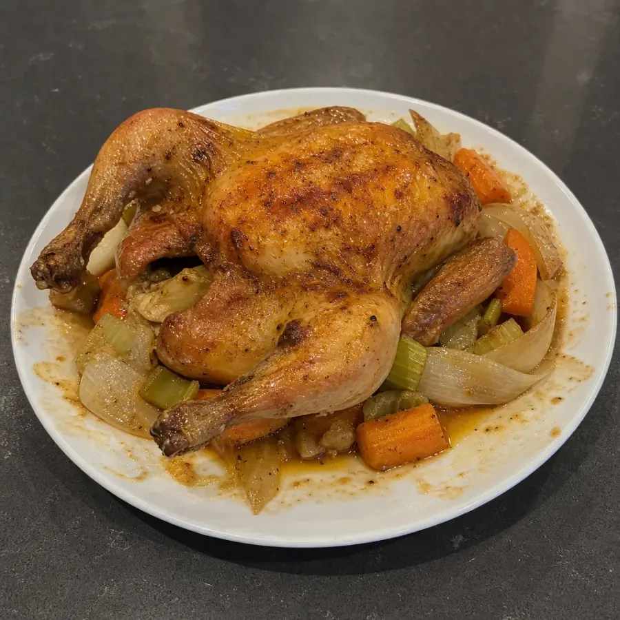 Poulet entier rôti au four, carottes, céleri et oignons